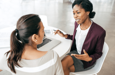 2 Frauen im Business-Look am Tisch in einem Beratungsgespräch