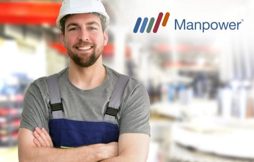 Industriearbeiter mit Helm vor einer Produktionshalle / Manpower