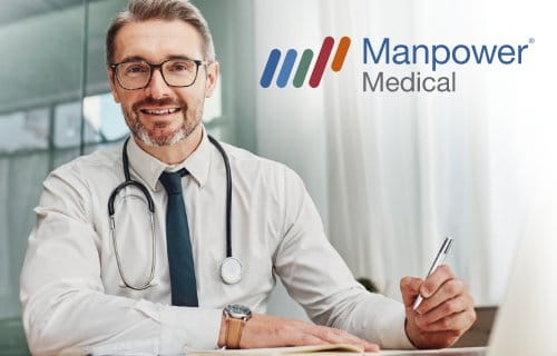 Arzt mit Stethoskop um den Hals am Schreibtisch sitzend / Manpower Medical
