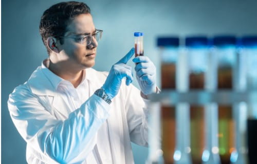 Chemielaborant mit Reagenzglas in der Hand
