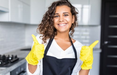 Küchenhilfe mit Schutzhandschuhen
