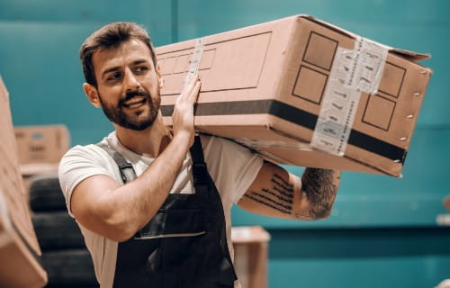 Lagerhelfer schultert ein Paket