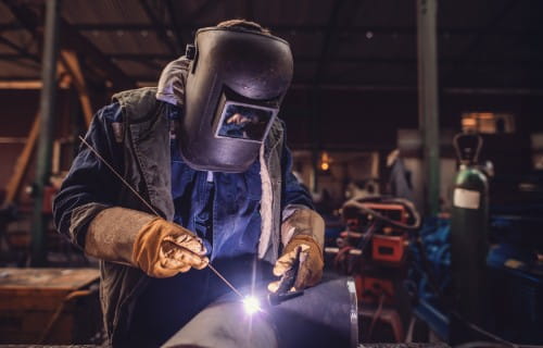 Schweißer bei der Arbeit im Schutzanzug
