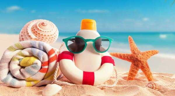 Utensilien für den Strandurlaub: Sonnenbrille, Creme, Handtuch und mehr
