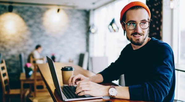 Freelancer in einem Cafe am Laptop arbeitend