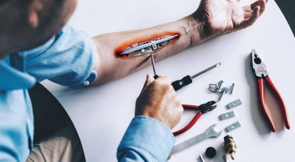 Person schraubt am eigenem (mechanischen) Arm mit Werkzeug rum