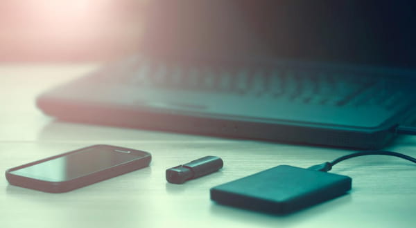 Laptop, Handy, Stick, Powerbank auf Tisch