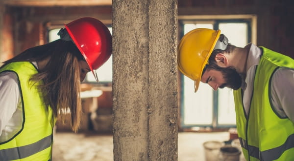 Arbeiter mit Helm, Kopf gegen die Wand