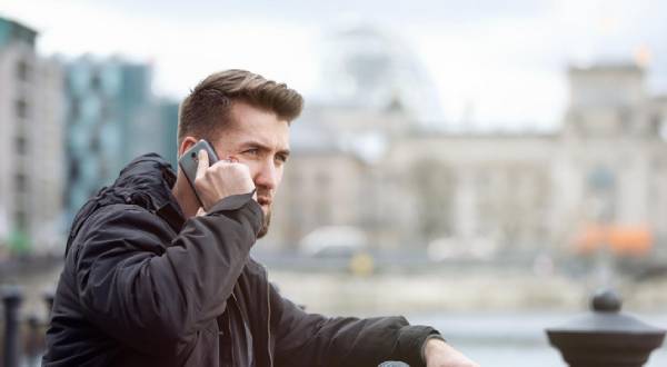 Mann draußen am Telefonieren