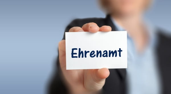 Karte mit "Ehrenamt" wird in die Kamera gehalten
