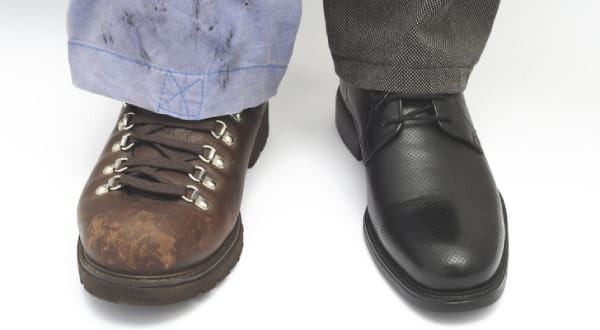 Linkes Bein: dreckige Arbeitshose und Arbeitsschuhe; Rechtes Bein: saubere Businesskleidung und feine Schuhe