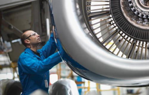 Mann arbeitet an einer Flugzeugturbine